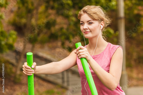 Active woman exercising on elliptical trainer.