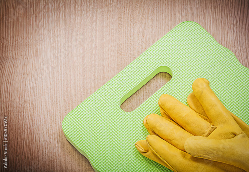 Pair of safety leather gloves garden mat on wooden board gardeni photo