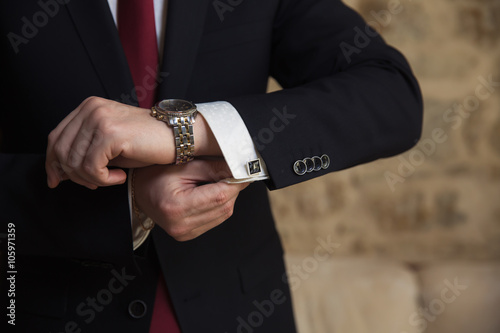Businessman fixing cufflinks his suit