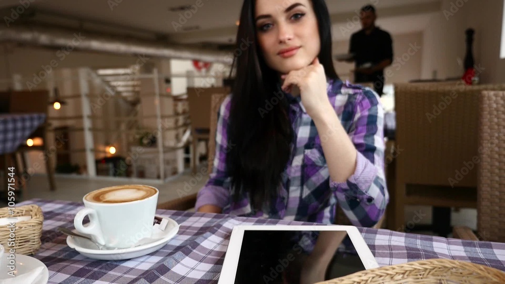 Young girl is sitting behind the table in the restaurant. Waiter brings plates with food.
Young girl is sitting behind the table in the restaurant. Waiter brings plates with food.
