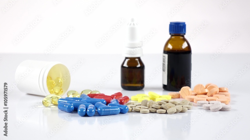 Lot of pills and doctor puts bottles with mixture on the table, white Lot of pills and doctor puts bottles with mixture on the table, white