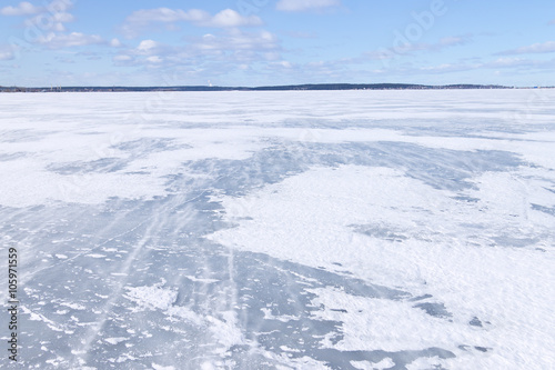 The surface of the lake covered with ice and blizzard