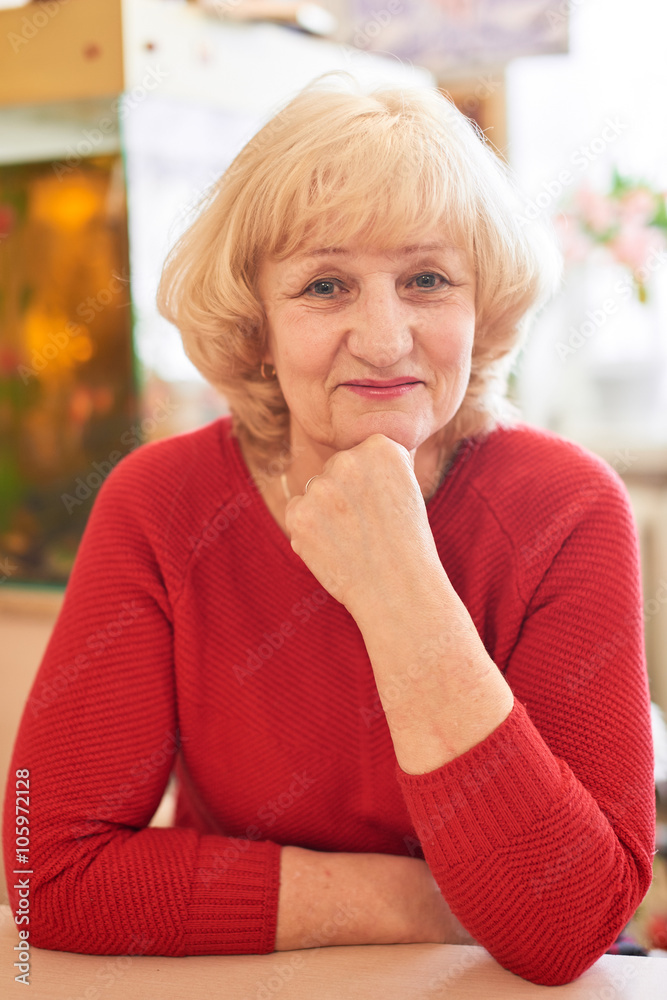 Happy elderly woman sitting in a red sweater Happy elderly woman sitting in a red sweater