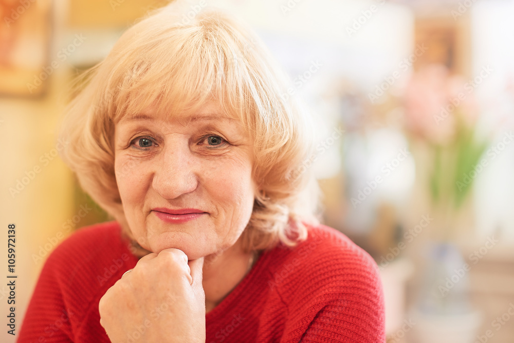 Happy elderly woman sitting in a red sweater Happy elderly woman sitting in a red sweater