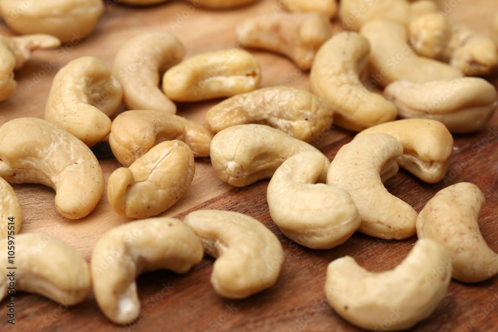 Raw cashew nuts on wooden table, detailed view Raw cashew nuts on wooden table, detailed view