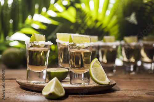 Gold tequila shots with lime fruits photo