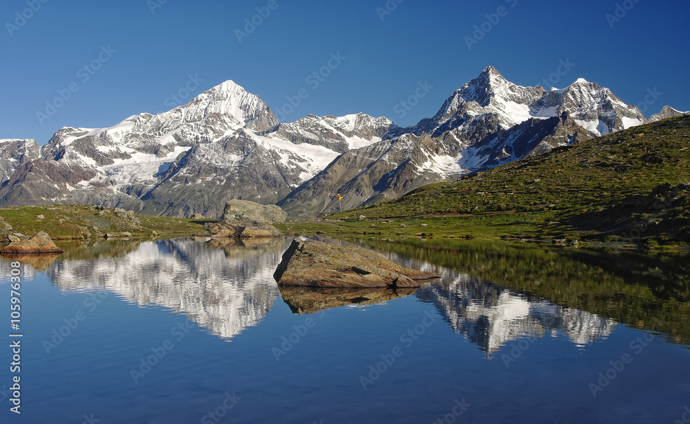 Alpine lake with reflection of mountains in water