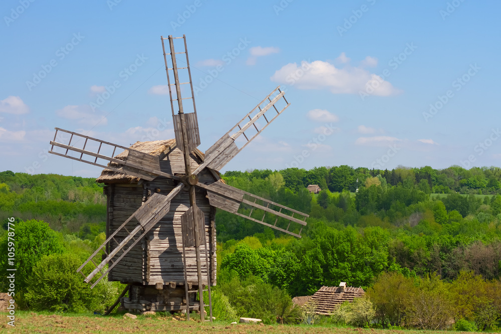 wooden windmill against the blue sky
