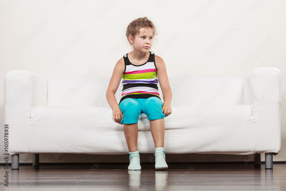 Fototapeta premium Tired exhausted lazy little girl kid sits on sofa