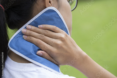 woman putting an ice pack on her neck pain photo