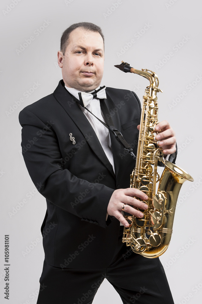 Fototapeta premium Relaxing Caucasian Man Posing With Saxophone Against White Background