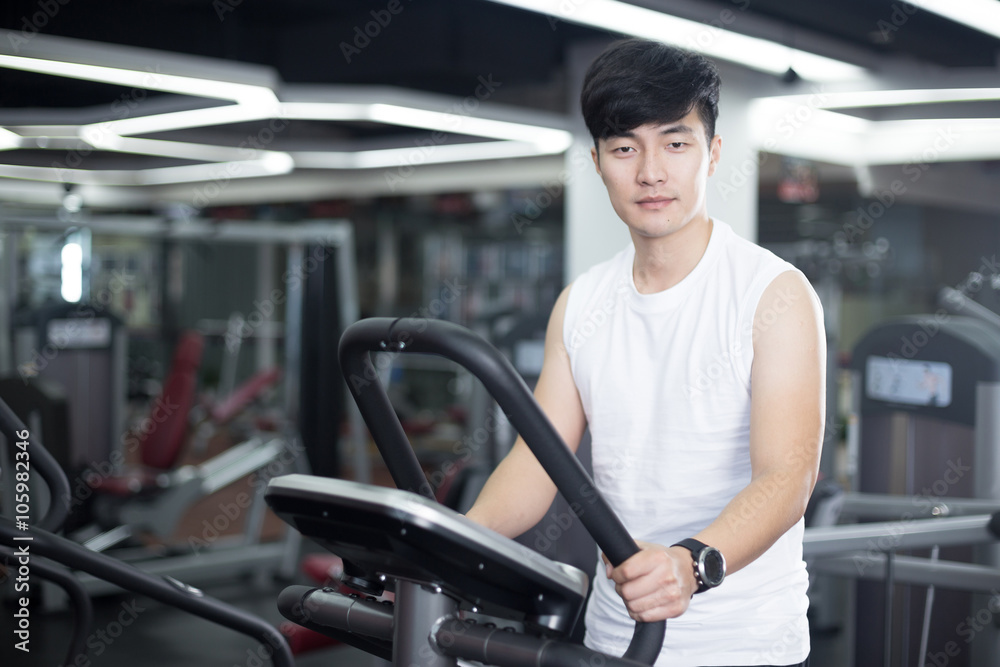 young handsome man works out in modern gym young handsome man works out in modern gym