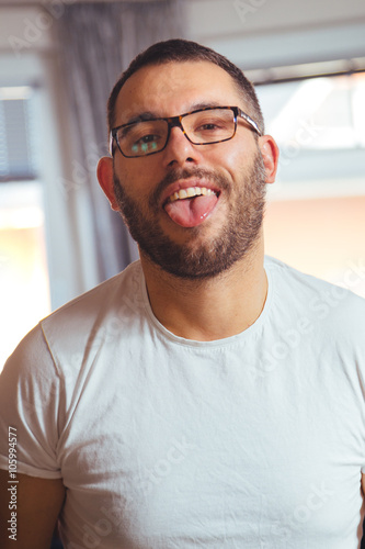Guy with glasses shows his tongue