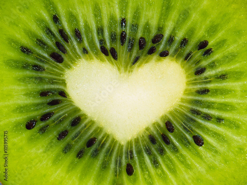 Green fruit kiwi close up with heart, green background