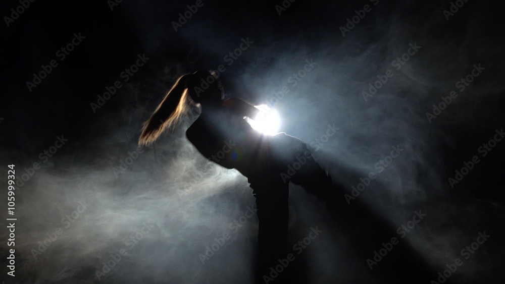 Girl athlete shows power karate moves. Black. Silhouette. Backlight