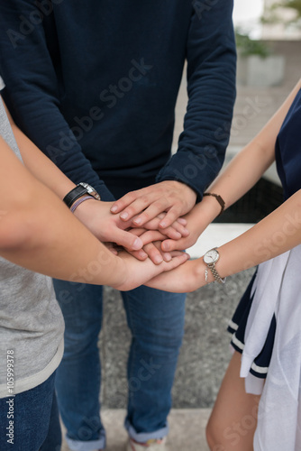 Stacked hands of young people as symbol of unity