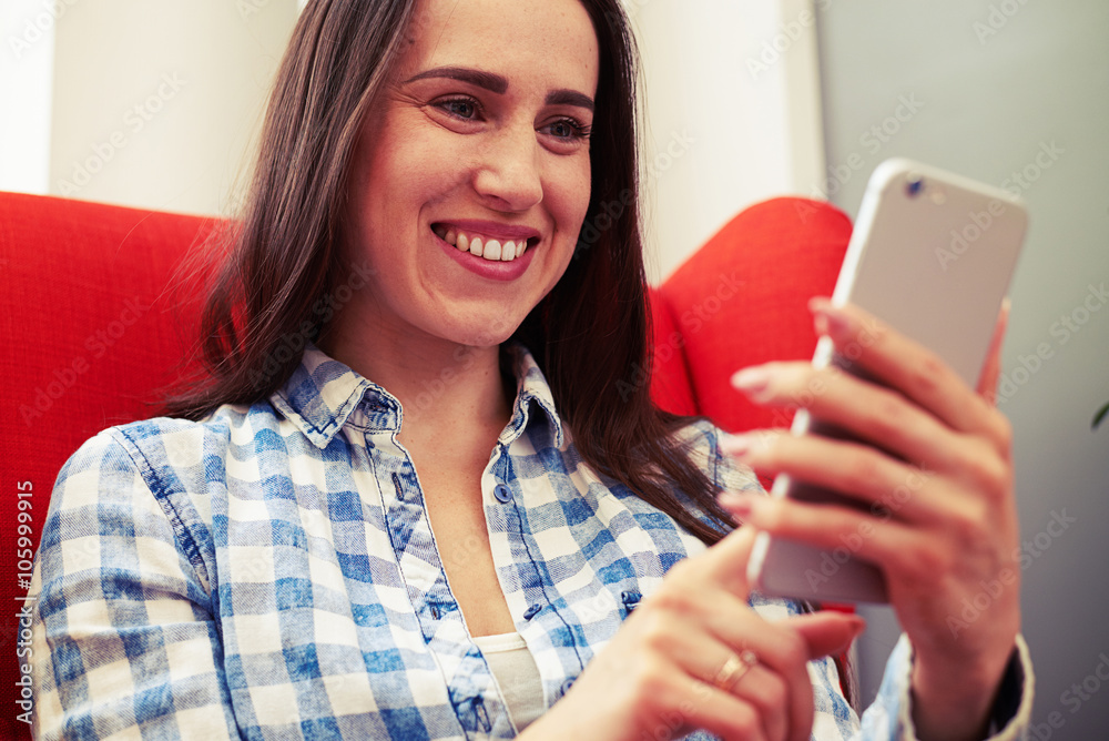 woman looking at smartphone and smiling woman looking at smartphone and smiling