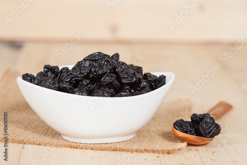 Raisin in the bowl on the wood background