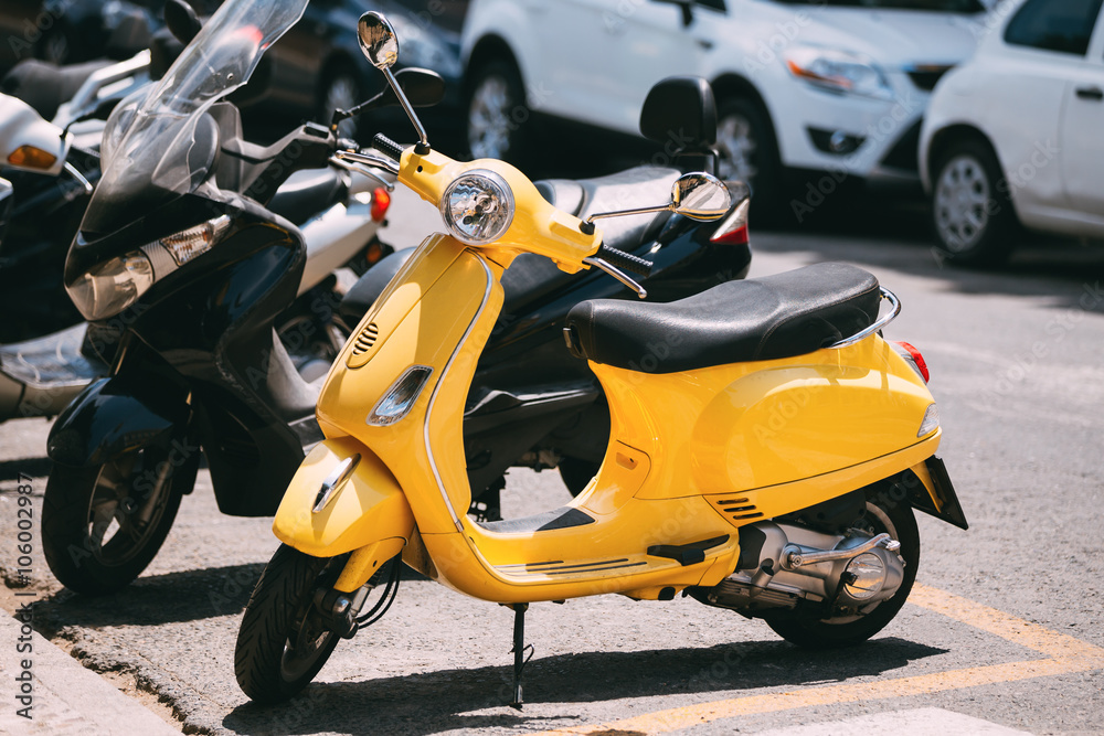 Naklejka premium Yellow motorbike, motorcycle scooter parked in city