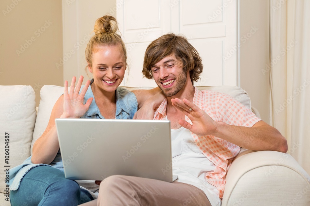 Cute couple using laptop sitting on the couch Cute couple using laptop sitting on the couch