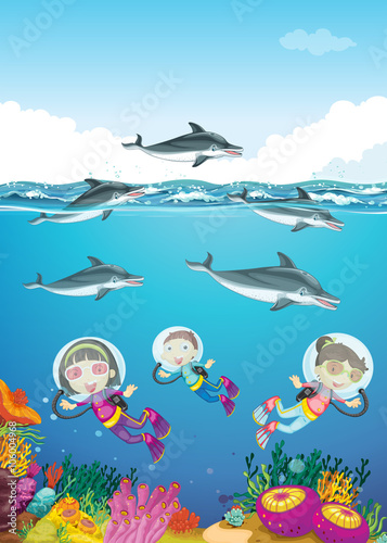 Dolphins and kids swimming under the sea