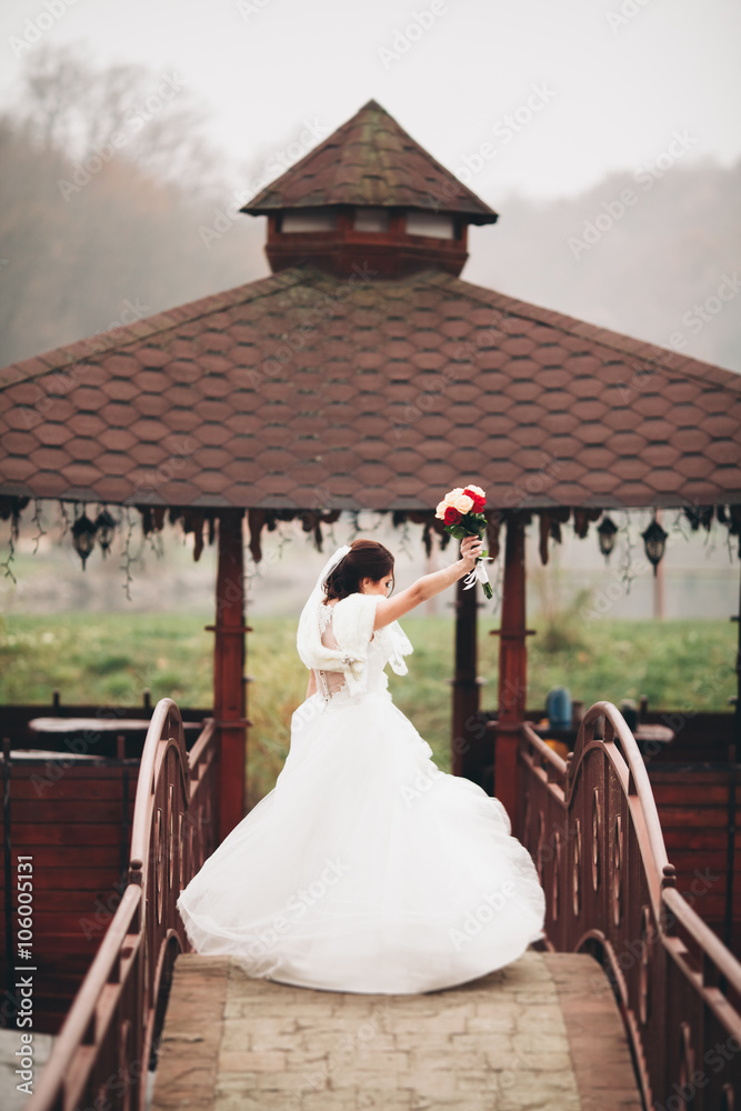 Fototapeta premium Beautiful luxury bride posing with a bouquet outdoors 