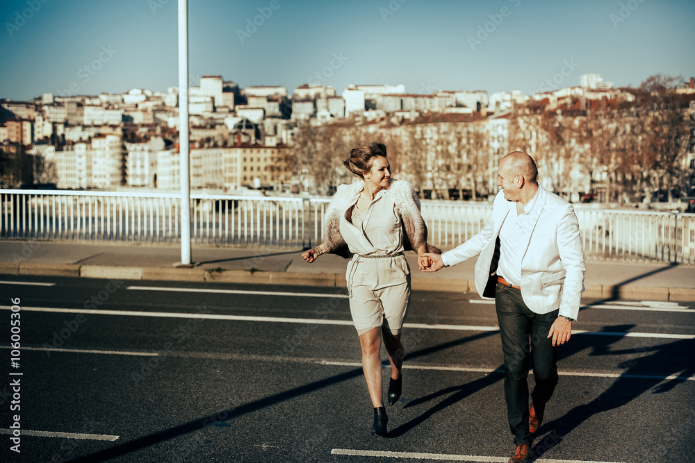 stylish beautiful rich bride and groom walking run on a sunny da