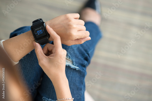 Hands of woman sending messages via smart watch