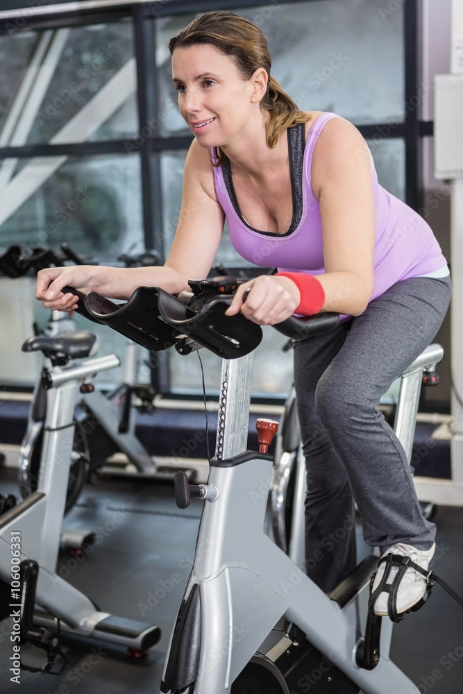 Smiling woman using exercise bike Smiling woman using exercise bike