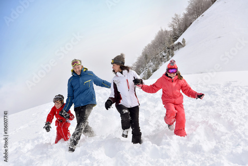 Family of 4 running down in snowy slope