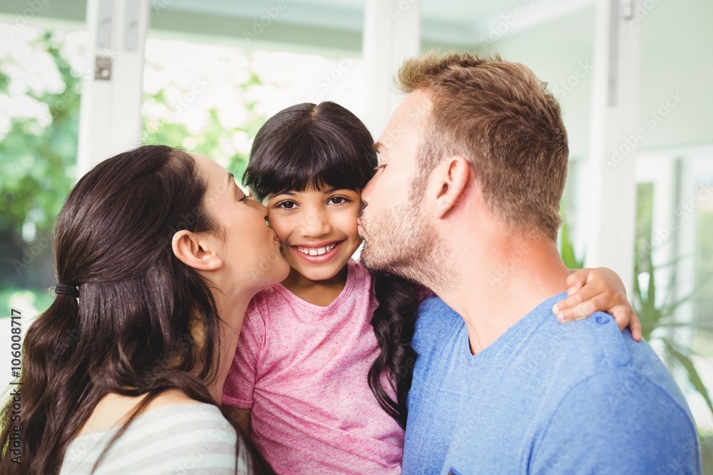 Fototapeta premium Father and mother kissing daughter