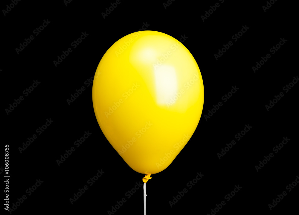 Yellow balloon on white ribbon isolated on black Yellow balloon on white ribbon isolated on black