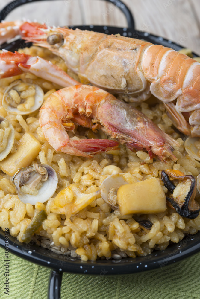 Vegetable paella with seafood on a wooden background