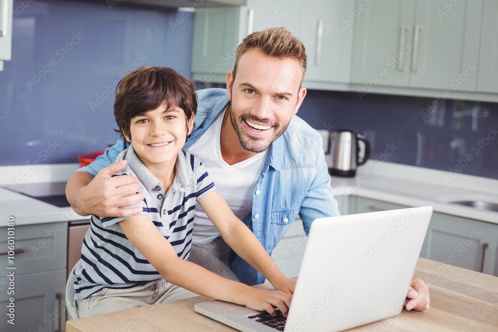 Portrait of smiling father and son using laptop Portrait of smiling father and son using laptop