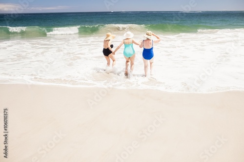 Senior woman friends running into water