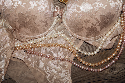 Bild auf Leinwand Sexy lace lingerie and pearls on a wooden board.