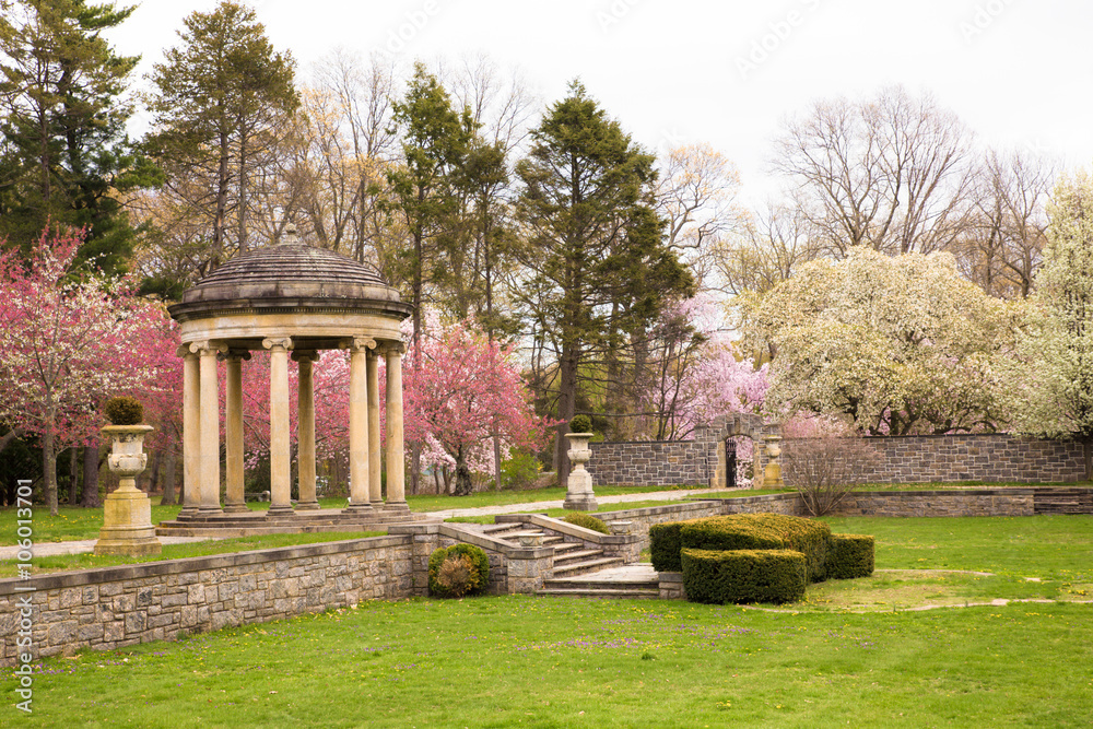 Spring trees in bloom in formal garden with marble gazebo 