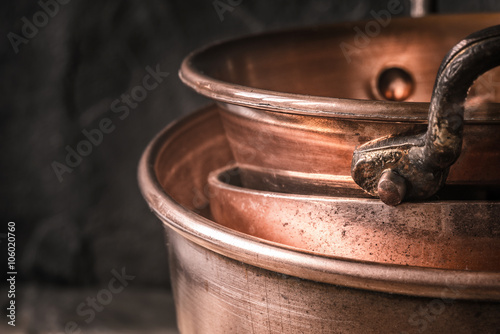 Copper pots and pans on the blurred background