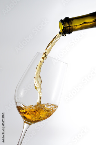 White wine pouring in a glass from a bottle