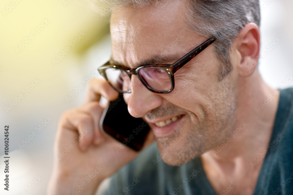 Mature handsome man with eyeglasses talking on phone Mature handsome man with eyeglasses talking on phone
