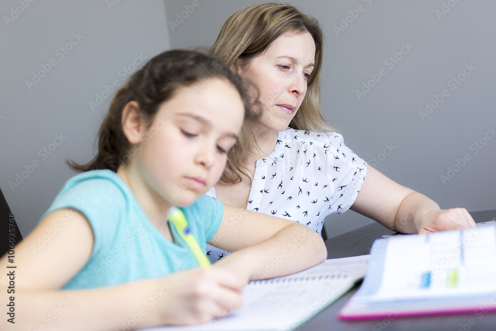 Mature mother helping her child with homework at home. Mature mother helping her child with homework at home.