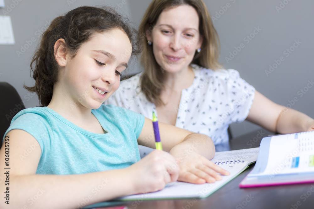 Mature mother helping her child with homework at home. Mature mother helping her child with homework at home.