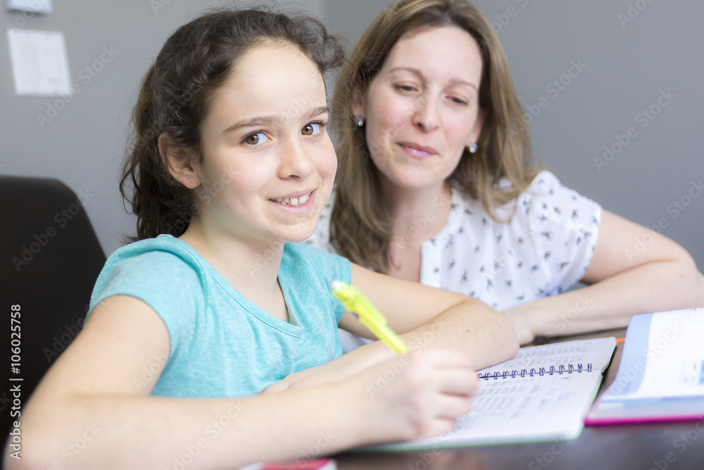 Mature mother helping her child with homework at home. Mature mother helping her child with homework at home.