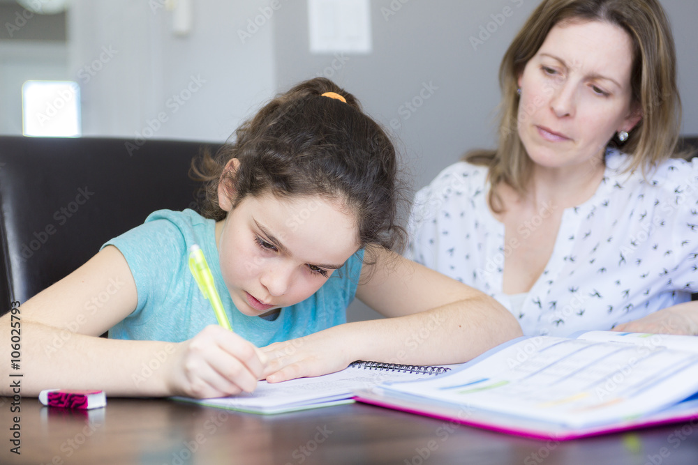 Mature mother helping her child with homework at home. Mature mother helping her child with homework at home.