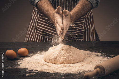 Fotografi Male hands knead the dough.