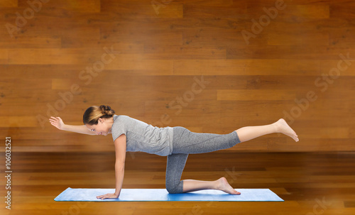 woman making yoga in balancing table pose on mat