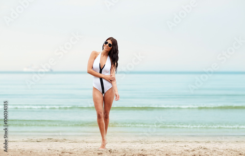 young woman in swimsuit posing on beach