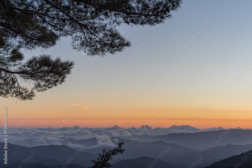 Panoramic view on mountain range with layer mist on evening glow background. Troodos, Cyprus.
