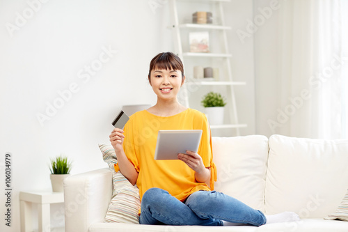 happy asian woman with tablet pc and credit card