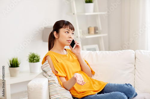 young asian woman calling on smartphone at home